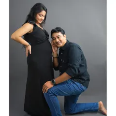 A playful and heartwarming moment. The father-to-be listens closely to the baby bump, sharing a smile with his partner. This is a classic couple maternity pose that captures the sweet anticipation of parenthood.