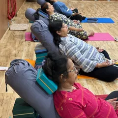 A view of our therapy yoga class, where each student is comfortably settled into a supported restorative pose. We ensure everyone has the right props to allow their body to completely let go and relax.