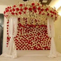 A bold and beautiful backdrop for Navratri, featuring a wall of red and white flowers. The design includes elegant white lace drapes, creating a perfect blend of vibrancy and grace for the festive season.