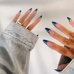 A cool and modern twist on the French manicure, using a deep navy blue chrome on long, elegant stiletto tips.