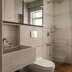A bathroom in Apartment 1005 featuring a custom marble sink and clean, modern fixtures. The design prioritizes functionality without sacrificing beauty, showcasing how we approach even the most utilitarian spaces with a designer's eye.
