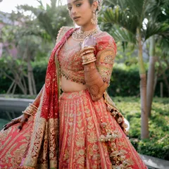 The bride, Jahanvi, looking absolutely radiant in her stunning pink and red lehenga. We helped coordinate this outdoor shoot to capture her beauty against a lush, natural backdrop.