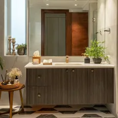 Luxury and relaxation meet in this well-appointed washroom. The floating vanity with dark wood grain contrasts beautifully with the bold, geometric-patterned floor, creating a spa-like escape.