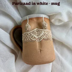 This is the 'Parizaad' mug in white, showcasing the delicate and intricate lace pattern. Each line is carved by hand, making every single mug a one-of-a-kind piece of functional art.