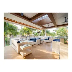 This bespoke terrace sit-out is the epitome of outdoor luxury. It features a sophisticated bar unit, comfortable wicker seating with navy cushions, and a high ceiling with skylights, seamlessly blending style and functionality.