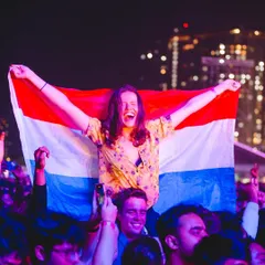 A fan flying the flag of the Netherlands high on someone's shoulders during Martin Garrix's set, showing the international love at our events.