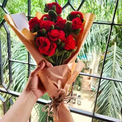 A full bouquet of classic red crochet roses, wrapped simply in brown paper and tied with twine. It’s a timeless, romantic gesture that will last a lifetime.