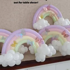 A beautiful set of pastel rainbow balloon arrangements we created for table decor. Each rainbow has fluffy white clouds and is adorned with delicate, shimmering paper butterflies.