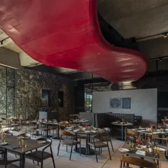 A dramatic, curving red ceiling feature flows through the restaurant at the Radisson Resort, contrasting with the rugged stone walls and adding a sculptural, artistic element to the space.