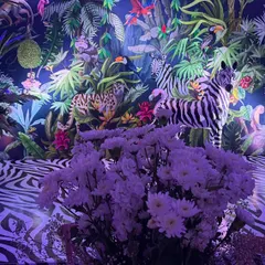 The combination of the patterned floor, the detailed backdrop, and the floral centerpieces creates a rich, layered environment that invites guests to explore.
