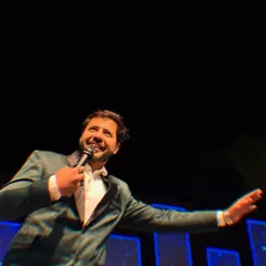 A candid shot of me on stage, mid-performance, with a huge smile. This is the authentic joy I bring to your most special occasions.