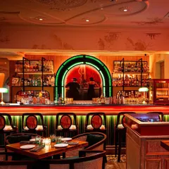 This shot of a stylish bar highlights how our art integrates with high-end interior design. The subtle, elegant mural work on the upper walls and the custom art behind the bar add a layer of sophistication and visual interest to the space.