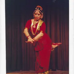 A classic solo performance photograph from my career. Dressed in a traditional red costume, this pose captures the balance and geometric precision that is a hallmark of the Kalakshetra style.