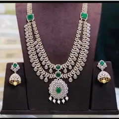 An elegant and modern layered necklace with leaf-patterned chains and green stone accents. This piece is light yet provides a rich, layered look.