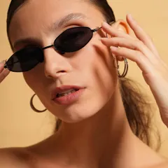 This portrait captures a confident and direct gaze. The focus is on the model's features and the stylish sunglasses, creating a polished and professional headshot for a model's portfolio.