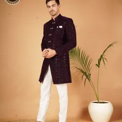 Elevate your style with this Indo-Western sherwani. The rich purple fabric and intricate pattern, paired with classic white trousers, create a look that is both traditional and fashion-forward.