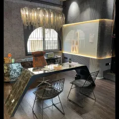 A glamorous and moody interior we designed for fashion designer Saniya Sardhariya's dance and fashion studio. The space features a custom curved desk, a dramatic chain chandelier, and dark, textured walls to create a unique and inspiring atmosphere.