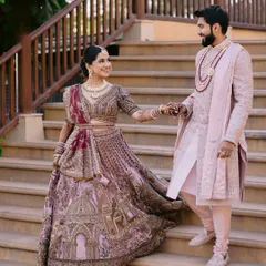 A grand entrance. This shot captures the couple's regal presence and the bride's unique, story-telling lehenga.