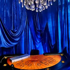 A close-up of the custom poker table under a magnificent crystal chandelier, ready for a high-stakes evening.