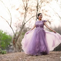 An outdoor shot featuring a flowing purple gown. The natural, golden-hour light creates a dreamy and romantic feel, perfect for evening wear lookbooks.