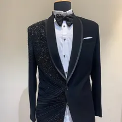 This mannequin showcases a jet-black tuxedo with an asymmetrical design. One side features heavy sequin and bead work with fabric ruching, while the other remains classic, offering a modern twist on formal wear.