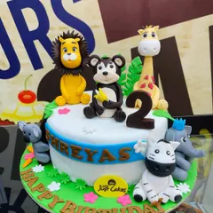 A delightful 3kg jungle cake for a second birthday, with fondant animals like a lion, monkey, and zebra.