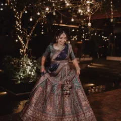 The bride twirls in her magnificent lehenga, the fairy lights creating a magical, dreamlike backdrop for this nighttime portrait.