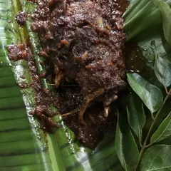 The final dish after being unwrapped. The fish is perfectly cooked, and the masala has thickened and caramelized around it, creating a taste sensation that is both rustic and refined.