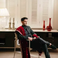 A relaxed yet sophisticated portrait of the groom. This shot captures his calm demeanor and sharp style, showcasing a modern groom's elegance.