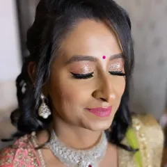 For this gorgeous reception look, we went with full-on glam. I created a sparkling glitter eyeshadow look with winged liner and a bright pink lip, paired with soft curls for a festive and modern style.