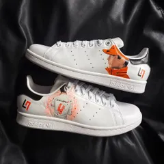A pair of crisp white Adidas Stan Smiths customized with a detailed portrait of McLaren F1 driver Lando Norris and his car number.