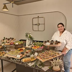 Co-founder Khyati Kale standing with a lavish grazing table she helped create. Her passion for design and detail is evident in every event we cater.