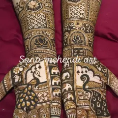 This detailed bridal mehendi is filled with auspicious symbols, including a procession of elephants, peacocks, and lotus flowers.