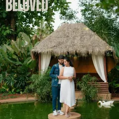 A romantic portrait at a beautiful resort. The couple stands on a small island in a pond, surrounded by lush greenery and swans, creating a fairytale-like setting for their pre-wedding shoot.