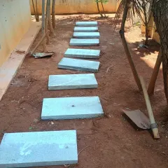 The stone pavers for the pathway are now laid out. The next step is to fill the surrounding area with soil and grass.