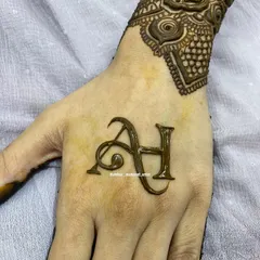 A clean and stylish initial design, featuring the letters 'AH' on the back of the hand. This is perfect for someone who wants a touch of personalization without a full hand design.