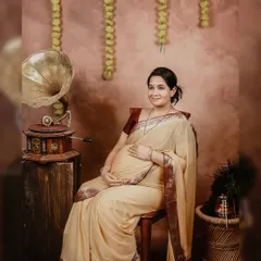 A full portrait of the mother-to-be, seated gracefully in our traditional setup. The warm lighting and classic props like the gramophone highlight the beauty of this special time.