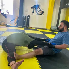 Another example of assisted stretching, where a training partner helps to deepen a stretch for better results and injury prevention.