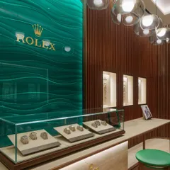 For the Rolex flagship boutique in Mumbai, we translated the brand's 119-year legacy into a physical space. The design uses a restrained palette of warm wood, travertino cladding, and the signature Rolex green to create an atmosphere of timeless elegance and refinement.