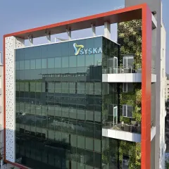 A daytime view of the Syska building facade, highlighting the lush green wall and glass exterior. We were integrating large-scale biophilic design years before it became a mainstream trend.