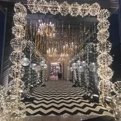 I make sure your guests are wowed from the moment they arrive. This glamorous Sangeet night entrance features a dramatic black and white chevron walkway, illuminated by thousands of fairy lights and sparkling chandeliers, setting the tone for an unforgettable party.