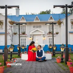 A sweet and romantic moment captured at the same lovely location. The groom sits at the bride's feet, creating a tender and intimate portrait.