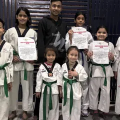 A group of our students, young and old, proudly holding their color belt test certificates. Each certificate is a step forward in their martial arts journey.