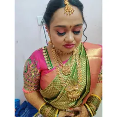 This bride's look for her muhurtham features a beautiful combination of pink and green. I used a soft pink eyeshadow and a matching lip color to complement her silk saree and intricate temple jewellery.