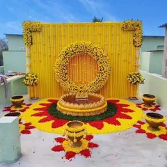 We transformed this terrace into a beautiful Haldi venue. The decor features a traditional yellow backdrop and an intricate flower rangoli on the floor, showing how we can utilize any space for your home wedding functions.