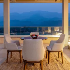 Unwind in elegance at this peaceful boutique retreat in Rishikesh, overlooking the beautiful Ganges. The outdoor dining area is designed for serene moments, with a stunning mountain view that complements the minimalist and sophisticated decor.