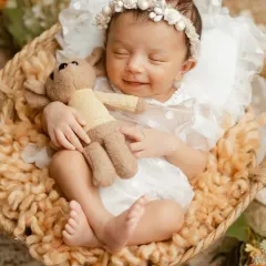 There is nothing more peaceful than a sleeping newborn. This little one gave us the sweetest smile while dreaming, a precious moment from one of our classic newborn photography sessions.