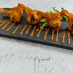 These are not just any prawns. We marinate them in a zesty chimichurri sauce and coat them in panko for an unbeatable crispy texture, served with an artistic drizzle of our house sauce.