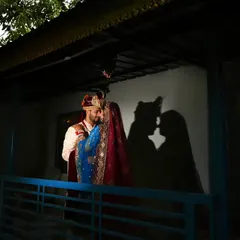 A creative wedding night portrait using shadows to tell a story. The silhouette of the couple about to kiss adds a touch of mystery and romance to their wedding album.