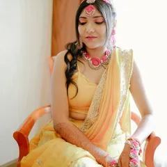 A serene portrait of the Haldi bride. The makeup is soft and radiant, designed to give her a natural glow for her pre-wedding ceremony.